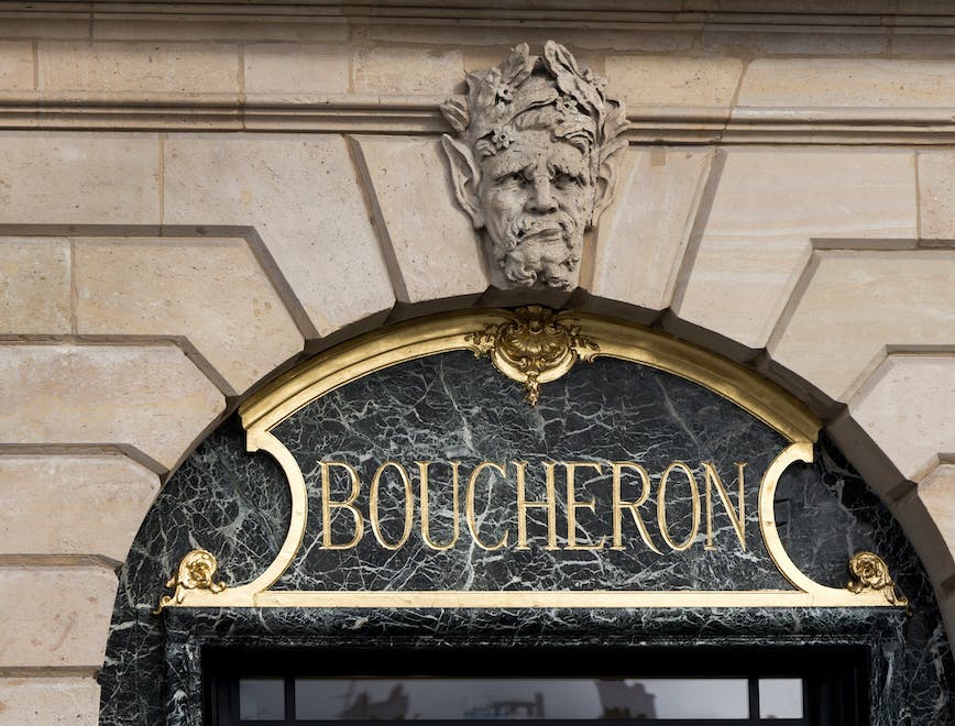 jewelry,symbol,city,icon,sign,store,urban,street,logo,text,emblem,europe,word,french,boucheron architecture building monastery arch person logo face head